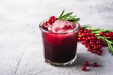 Fresh ice cold fruit cocktail in glass, refreshing summer red currant berry drink with rosemary leaf on stone concrete background, angle view clipart