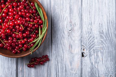 Tahta kasede biberiye yapraklı taze üzümler, gri ahşap arka plan, üst görünüm kopyalama alanı.