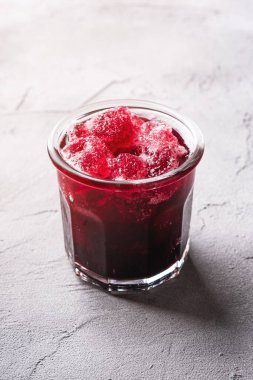 Bardakta taze buz gibi meyve kokteyli, sert arka planda taze kırmızı frenk üzümü içeceği, açı manzarası.