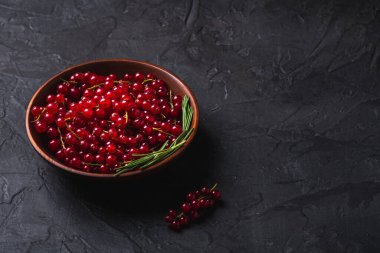 Ahşap kasede biberiye yapraklı taze üzümler, koyu dokulu arka plan, açı görüşlü kopyalama alanı.