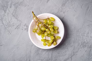 Taze beyaz üzüm meyveleri ahşap kasede beton arka planda, üst tarafta.