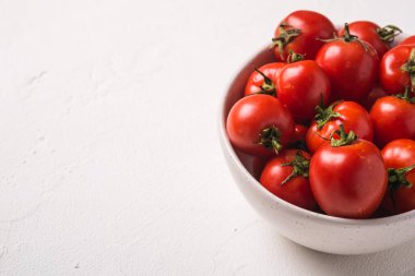 Taze olgun domatesler ve su damlaları beyaz beton arka planda, açı görünümü kopyalama alanı