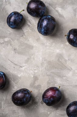 Taş zeminde su damlaları olan taze erik meyveleri, üst görünüm kopyalama alanı