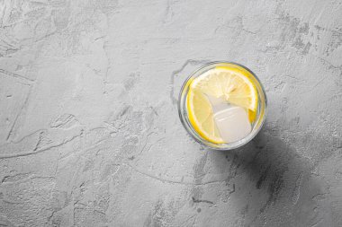 Beton zemin üzerinde limonlu taze buzlu su içeceği, üst görünüm kopyalama alanı
