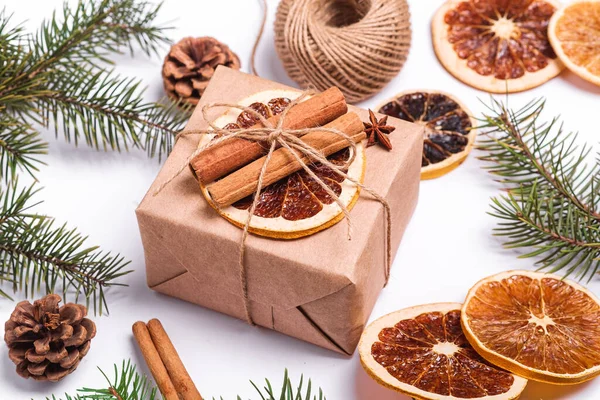 El yapımı Kraft kağıt hediye kutusu, kurutulmuş narenciye dilimleri, tarçın, anason, çam kozalakları ve köknar ağacı dallarıyla Noel kompozisyonu.