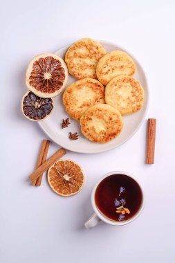 Süzme peynirli börek, sıcak siyah aromalı çay, beyaz arka planda anason ve tarçınlı Noel kahvaltısı havası.
