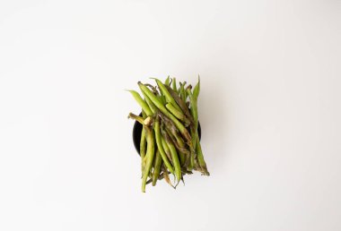 Bozuk, çürümüş yeşil fasulyeli bir kâsenin yakın plan fotoğrafı. Çürümüş ve kahverengi lekeler, beyaz arka planda izole edilmiş..