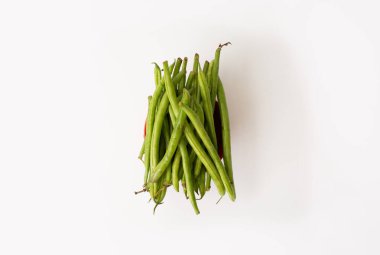 Taze yeşil fasulyeli bir kâseye yakın plan, yatay ekin, beyaz arka planda fotoğraflanmış..