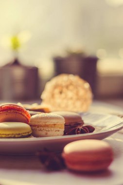 Görüntü güneş ışığı yakın çekim sığ derinlik-in tarla plaka üzerinde renkli makarna macaroons tonda