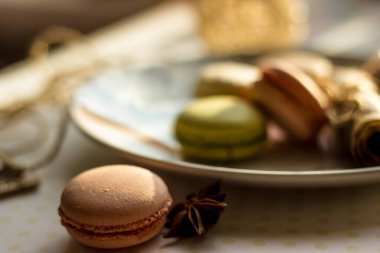 Görüntü güneş ışığı yakın çekim sığ derinlik-in tarla plaka üzerinde renkli makarna macaroons tonda