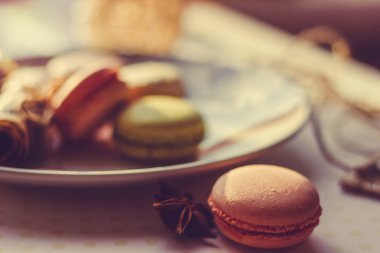 Görüntü güneş ışığı yakın çekim sığ derinlik-in tarla plaka üzerinde renkli makarna macaroons tonda