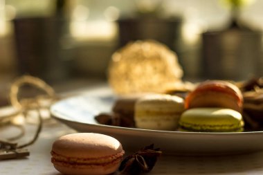 Görüntü güneş ışığı yakın çekim sığ derinlik-in tarla plaka üzerinde renkli makarna macaroons tonda