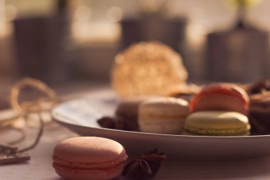 Görüntü güneş ışığı yakın çekim sığ derinlik-in tarla plaka üzerinde renkli makarna macaroons tonda