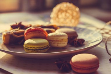 Görüntü güneş ışığı yakın çekim sığ derinlik-in tarla plaka üzerinde renkli makarna macaroons tonda