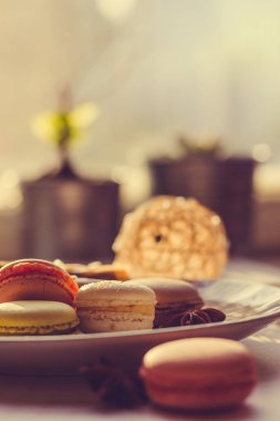 Görüntü güneş ışığı yakın çekim sığ derinlik-in tarla plaka üzerinde renkli makarna macaroons tonda