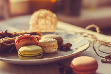 Görüntü güneş ışığı yakın çekim sığ derinlik-in tarla plaka üzerinde renkli makarna macaroons tonda