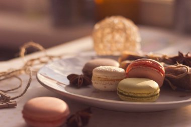 Görüntü güneş ışığı yakın çekim sığ derinlik-in tarla plaka üzerinde renkli makarna macaroons tonda