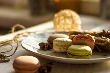 Görüntü güneş ışığı yakın çekim sığ derinlik-in tarla plaka üzerinde renkli makarna macaroons tonda