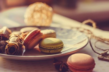 Görüntü güneş ışığı yakın çekim sığ derinlik-in tarla plaka üzerinde renkli makarna macaroons tonda