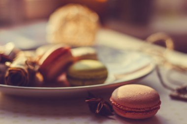 Görüntü güneş ışığı yakın çekim sığ derinlik-in tarla plaka üzerinde renkli makarna macaroons tonda