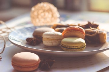 Görüntü güneş ışığı yakın çekim sığ derinlik-in tarla plaka üzerinde renkli makarna macaroons tonda