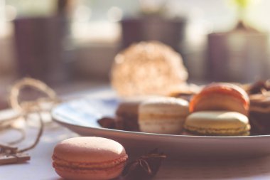 Görüntü güneş ışığı yakın çekim sığ derinlik-in tarla plaka üzerinde renkli makarna macaroons tonda