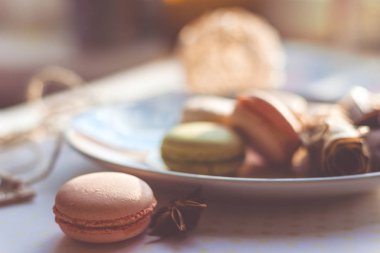 Görüntü güneş ışığı yakın çekim sığ derinlik-in tarla plaka üzerinde renkli makarna macaroons tonda