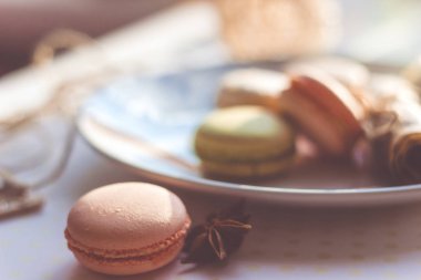 Görüntü güneş ışığı yakın çekim sığ derinlik-in tarla plaka üzerinde renkli makarna macaroons tonda
