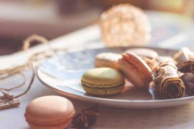 Görüntü güneş ışığı yakın çekim sığ derinlik-in tarla plaka üzerinde renkli makarna macaroons tonda