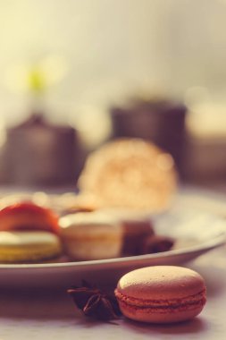 Görüntü güneş ışığı yakın çekim sığ derinlik-in tarla plaka üzerinde renkli makarna macaroons tonda