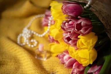 Pembe ve sarı lale buketi sarı örme kumaş üzerinde yalan