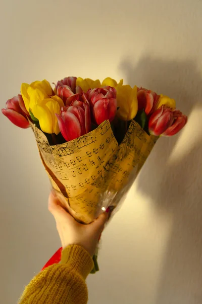 女の子の手にピンクと黄色のチューリップの花束 — ストック写真