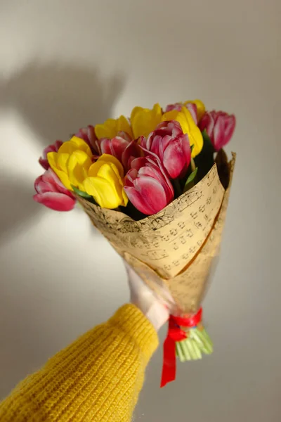 Розовый и желтый букет тюльпанов в руке девушки — стоковое фото