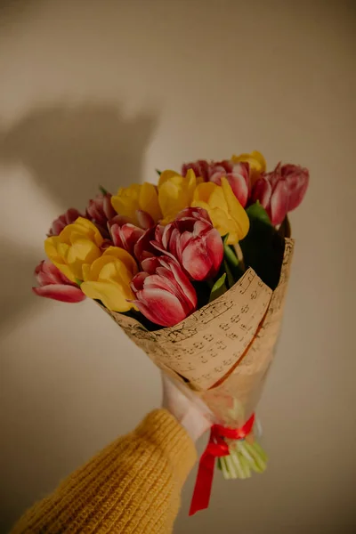 粉红色和黄色的郁金香花束在女孩的手 — 图库照片
