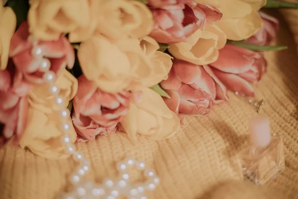 Букет из розовых и желтых тюльпанов, лежащий на желтой трикотажной ткани — стоковое фото