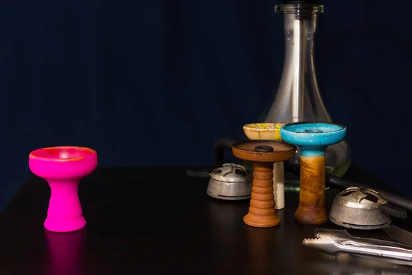 Hookah and four different hookah bowls and kalaud on the table c — Stock Photo, Image