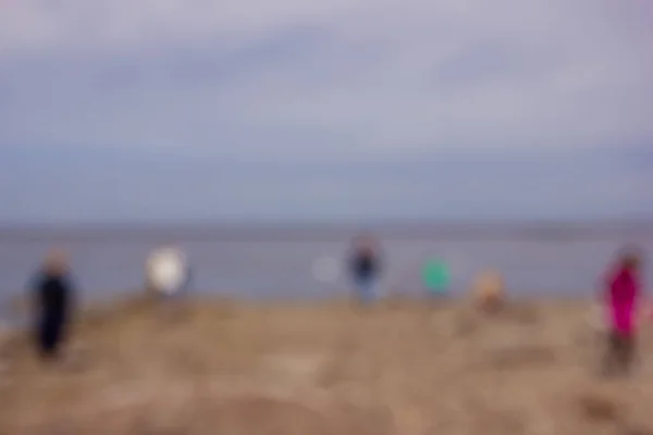 Blurred image of people walking on the seaside — Stock Photo, Image
