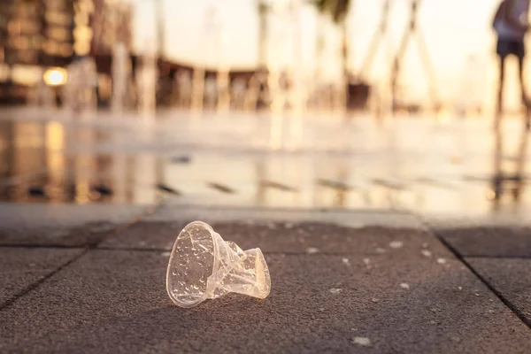 Copa de plástico acostado en el pavimento cerca de la fuente seca —  Fotos de Stock