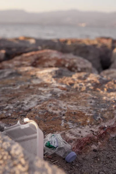 IZMIR, TURQUÍA, 29 DE JULIO DE 2019: basura en piedras en la costa del mar —  Fotos de Stock