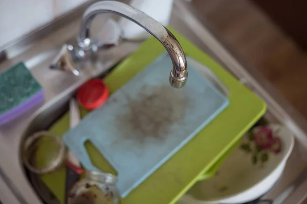 Dirty dishes and chopping boards lie in the sink — Stock Photo, Image