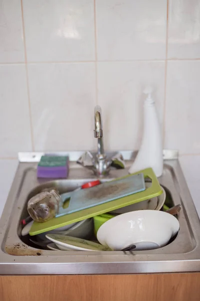 Грязная посуда и доски лежат в раковине — стоковое фото