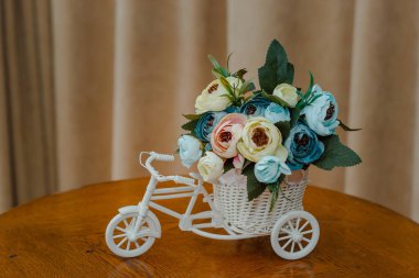 bir bisiklet şeklinde dekoratif tencerede yapay çiçekler