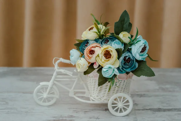 Искусственные цветы в декоративном горшке в виде велосипеда — стоковое фото