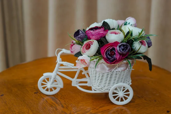 Искусственные цветы в декоративном горшке в виде велосипеда — стоковое фото