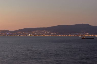 İzmir'de koyda gün batımı manzarası, gemi ve dağlar