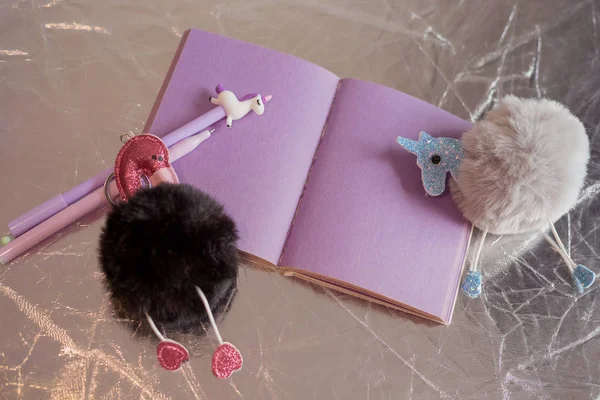 Girlish things still life. Notepad with purple pages, a fluffy b — Stock Photo, Image