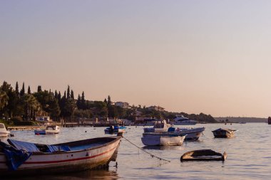 Kıyıdan denizde teknelere Ildiri köyü manzarası, gün batımı zamanı