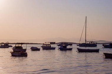 Kıyıdan denizde teknelere Ildiri köyü manzarası, gün batımı zamanı