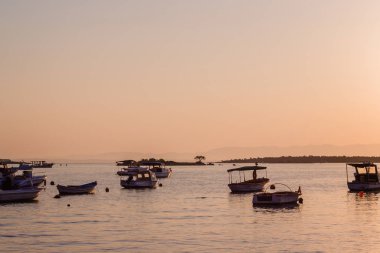 Kıyıdan denizde teknelere Ildiri köyü manzarası, gün batımı zamanı
