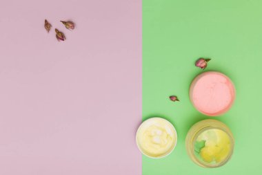 Kozmetik kremler renklendirilmiş arka planda yatıyordu.